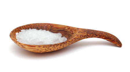 wooden spoon full of coarse grain sea salt from Gran Canaria isolated on white backgroundの写真素材
