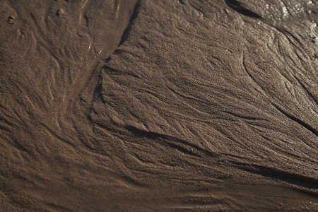 natural sand pattern created by a flow of tide and ripples on the edge of a beach