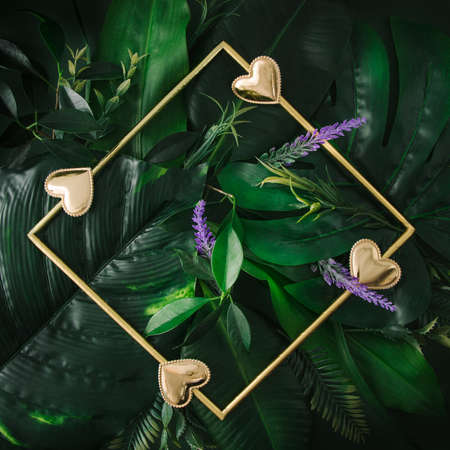 Golden elegant frame with green tropical leaves. Place for text in the triangle. Minimal concept.