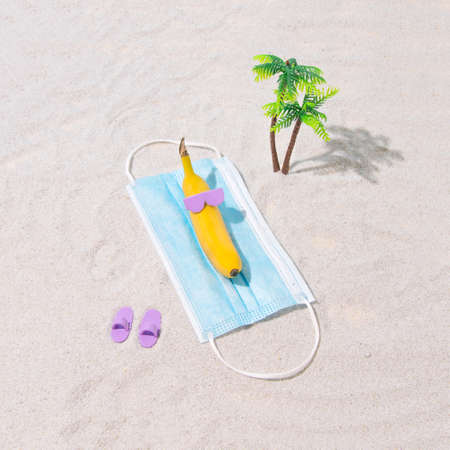Sunbathing on the beach during the pandemic. Yellow banana sunbathing on the beach and lying on a...