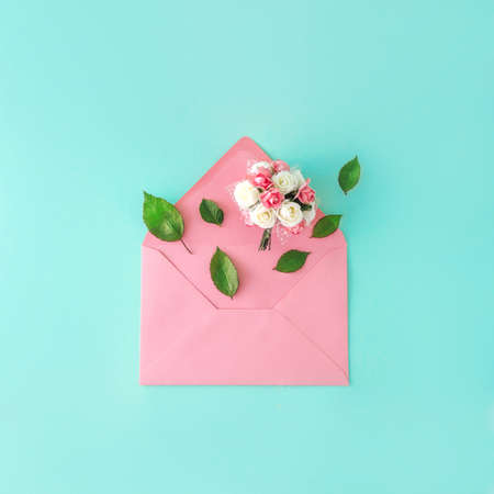 Flowers coming out of a pink envelope. Biedermeier. Blue background. Rose Petals.の写真素材