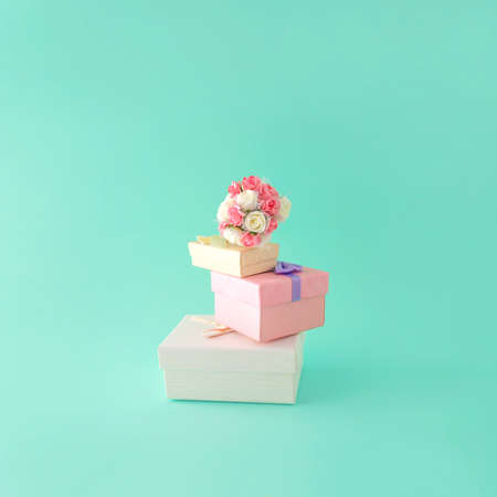 Wedding gifts. Bouquet of flowers. Turquoise background. Minimal composition.の写真素材