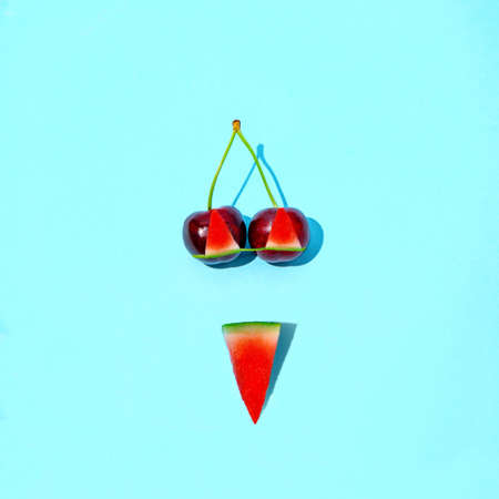 Watermelon summer swimsuit. Cherries like breasts. Women's swimsuit. Blue background. Minimal tropical composition.の写真素材