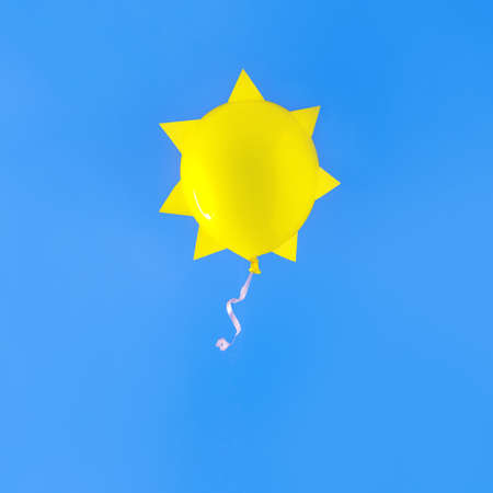 Yellow balloon sun. On a blue background. Minimalism. The sky. Fly balloon.の写真素材