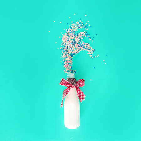 A white bottle with a bow from which sequins come out like fireworks. A party, a women's...
