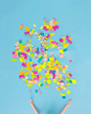 A person who throws colorful confetti in the air. Celebration, party. Blue background.の写真素材