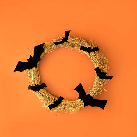 Creative look made of autumn tree branches with bats. Minimum flat laying. Halloween concept. On an orange background.の写真素材