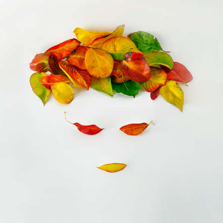 Autumn leaves in the shape of a woman's face and hair. Creative leaves idea.