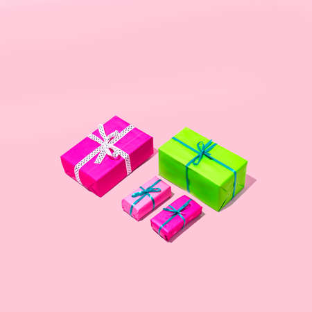 Christmas and party gifts in pink and green colors. Minimal holiday composition on a pink...