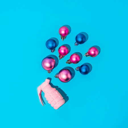 New Year's explosion of pink bomb decorations. Minimal aesthetics of a Holiday idea on a blue background.の写真素材