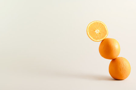 Couple of leaning oranges , on a grey-neutral background