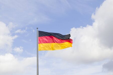 Germany national flag, red, black and yellow colors on the blue sky background.の写真素材