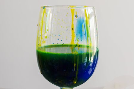 Paint in wineglass, red and blue colors water, art photo.の写真素材