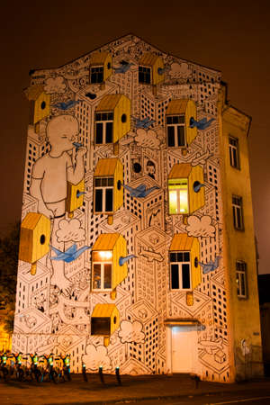 VILNIUS, LITHUANIA - OCTOBER 17, 2017: Mural on the building exterior, night and yellow lightsのeditorial素材