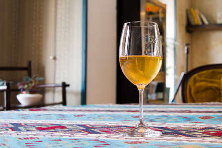 Full wineglass with white wine on the table in the restaurant, cafe and bar. White wine in wineglass, Tbilisi, Georgia.の写真素材