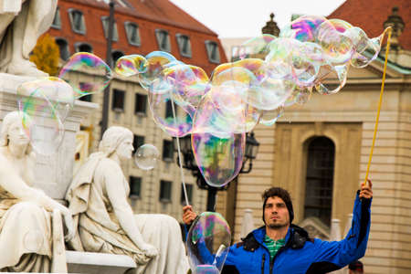 Soap bubbles in the street of Berlin, Germany. Man entertain people and tourist near the concert...