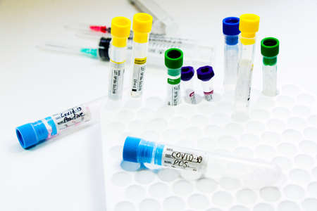 Corona virus and Covid-19 positive blood test tubes on the white background, studio shoot. Blood...