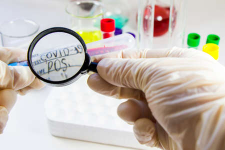 Covid - 19, corona or covid blood test tube sample, doctors hand and magnificent glass.