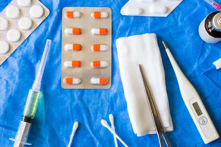 Body thermometer, drugs, needle and ampule on the sterile tableの写真素材