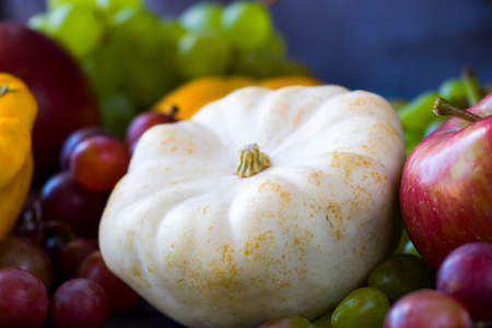 Autumn and fall harvest, pumpkin, apple, grape and pattison on the blue backgroundの写真素材