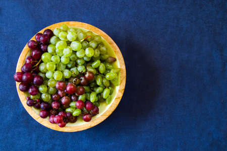 Autumn grapes on the blue background, harvesting seasonal fruit