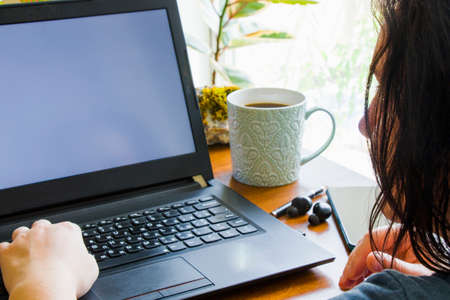Workspace, notebook, mobile phone, coffee and plants in workspace, home working