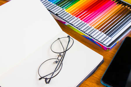 Drawing and painting table, sketching pencils and sketchbook, empty paper and colorful pencils