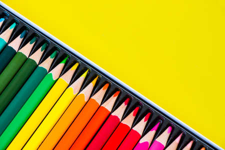 Multicolored and colorful pencils on the yellow background, stationary thing for drawing and paint