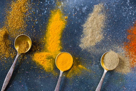 variation of spices on the vintage silver spoons, all spices on the table, colorful food backgroundの写真素材