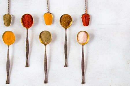 variation of spices on the vintage silver spoons, all spices on the table, colorful food backgroundの写真素材