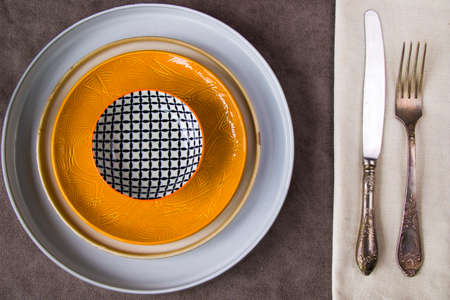 Empty tableware and dishware settings and serving on the gray background, plate, bowl, vintage folk and knifeの写真素材