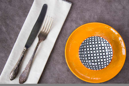 Empty tableware and dishware settings and serving on the gray background, plate, bowl, folk and knifeの写真素材