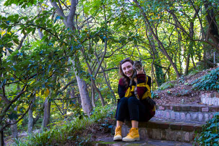 Woman and cat in the botanic garden and park, trees and casual young girl portrait in gardenの写真素材