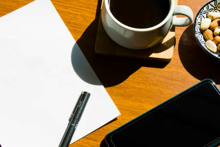 Working from home, workspace with tablet and mobile phone, coffee and workplace. Paper and pen.