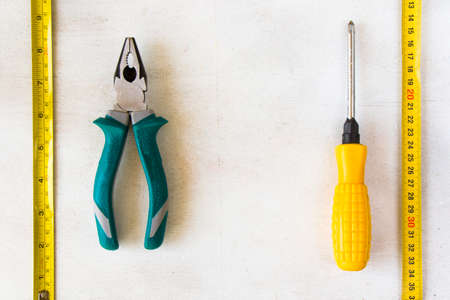 Tape measure and pliers on the white background, building instruments