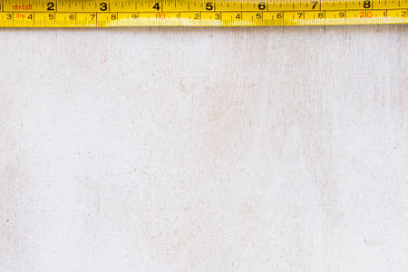 Tape measure centimeters and millimeters on the yellow ruler. Sizes on the white background