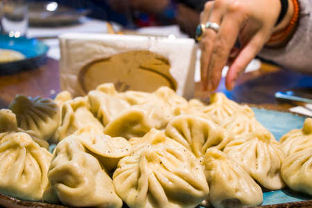 Georgian khinkali on the table and hand in restourantの写真素材