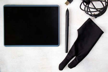 Drawing and painting tablet, glove and pen on the white background, high angle view