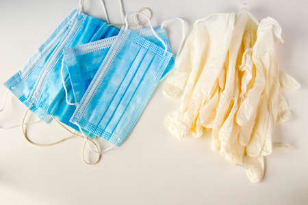Medical gloves and face masks on the white background, sterile protection