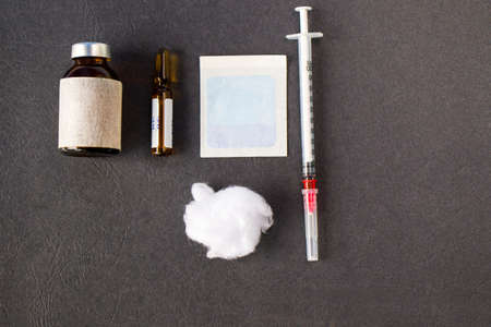 Vaccine ampule, needle and cotton on the gray background, vaccine injection
