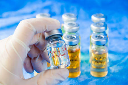 Corona virus and Covid - 19 doctors hand holding a vaccine, new vaccine in bottles, different color...