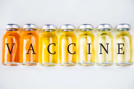 New vaccine in ampules, different color variations of vaccine on the white background, bottle and...