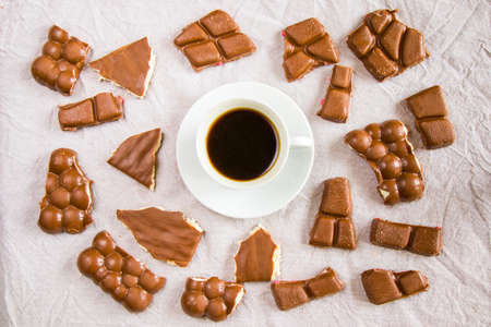 Cup of black espresso coffee and chocolate bars on the white cloth background, morning coffee time