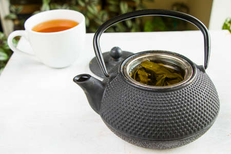 Herbal tea, iron teapot and cup of tea on the white background, chinese traditional tea serving