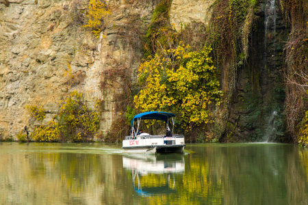 Tbilisi, Georgia - December 1, 2020: Mtkvari river and boat, autumn time trees and landscape in the...