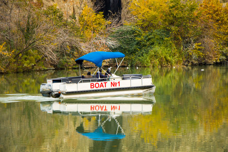 Tbilisi, Georgia - December 1, 2020: Mtkvari river and boat, autumn time trees and landscape in the city center of Tbilisiのeditorial素材