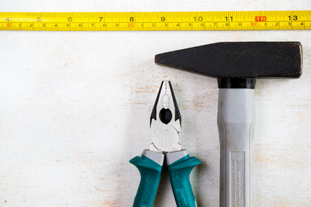 Building instrument set on the white background, tape measure, ruler and hammer, high angle view