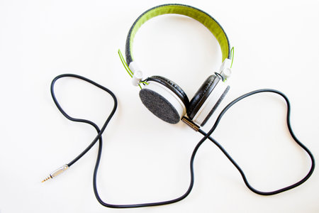 Earphones on the white background, cable and green digital audio accessoryの写真素材