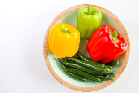 All colors bell pepper and green pepper in the bowl on the white backgroundの写真素材