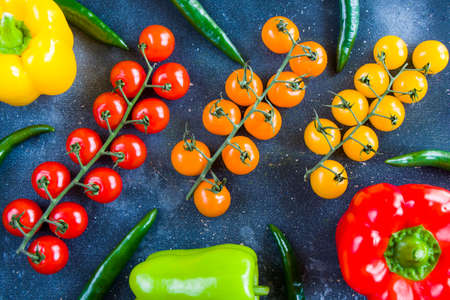 All color bell pepper, green spacy pepper and cherry tomatoes, colorful vegetables background, raw ingredientsの写真素材